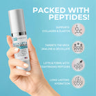 Hand holding a skincare serum bottle with product features on a blue background