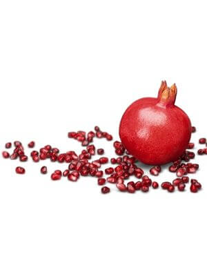 Whole red pomegranate with scattered ruby-red seeds on a white background